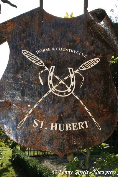 Het gietijzeren embleem van St. Hubert Horse & Country Club — gekruiste polomallets en hoefijzer, Kapellen